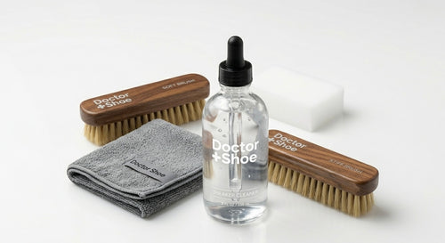 Set of shoe care products including brushes and a bottle on a white background