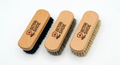 Three wooden shoe brushes with bristles on a white background, branded 'Doctor Shoe'.
