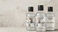 Three bottles of Doctor Shoe sole cleaner on a light background